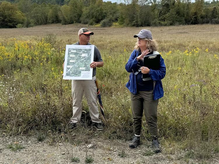 Two people stand in a field